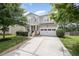 Charming two-story home with a manicured lawn, two-car garage, and covered front porch at 1211 Whispering Oak Ln, Durham, NC 27704