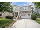 Charming two-story home with a manicured lawn, two-car garage, and covered front porch at 1211 Whispering Oak Ln, Durham, NC 27704