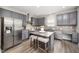 Modern kitchen featuring stainless steel appliances, granite countertops, and a breakfast bar at 1211 Whispering Oak Ln, Durham, NC 27704