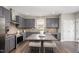 Gray kitchen has stainless appliances, granite countertops and a central island with seating for two at 1211 Whispering Oak Ln, Durham, NC 27704