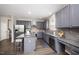 Stylish kitchen with gray cabinetry, stainless steel appliances, and a granite-topped island at 1211 Whispering Oak Ln, Durham, NC 27704