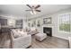 Cozy living room with a gray sofa, fireplace, lots of light and an open connection to kitchen at 1211 Whispering Oak Ln, Durham, NC 27704