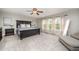 Spacious main bedroom with carpet, large dark-wood bed, and bright windows at 1211 Whispering Oak Ln, Durham, NC 27704