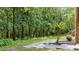 Lush backyard showcasing a serene landscape, mature trees, and a stone pathway leading to the home at 12504 Bayleaf Church Rd, Raleigh, NC 27614