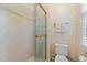 This bathroom features a glass-enclosed shower, a toilet, and patterned wallpaper. The floor is tiled at 12504 Bayleaf Church Rd, Raleigh, NC 27614