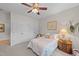 Bright bedroom features neutral walls, carpet, and a ceiling fan, creating a serene and inviting space at 12504 Bayleaf Church Rd, Raleigh, NC 27614