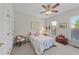 Cozy bedroom featuring a ceiling fan, two windows, and a comfortable bed with floral pattern bedding at 12504 Bayleaf Church Rd, Raleigh, NC 27614