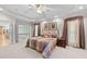 Large primary bedroom with neutral colored walls, plush carpet, and access to an outdoor balcony at 12504 Bayleaf Church Rd, Raleigh, NC 27614