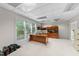Well-lit home office with a large window, built-in shelving, a modern desk, and neutral carpeting at 12504 Bayleaf Church Rd, Raleigh, NC 27614
