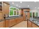 Bright kitchen featuring custom cabinetry, granite countertops, and a large window overlooking the backyard at 12504 Bayleaf Church Rd, Raleigh, NC 27614