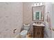 Traditional-style powder room featuring patterned wallpaper, and a carved vanity with a stone countertop at 12504 Bayleaf Church Rd, Raleigh, NC 27614