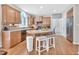 Well-lit kitchen features an island with seating, hardwood floors, stainless steel appliances, and wooden cabinetry at 1309 Caribou Xing, Durham, NC 27713