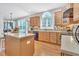 Spacious kitchen with a central island, wood cabinets, and lots of natural light from windows overlooking the yard at 1309 Caribou Xing, Durham, NC 27713