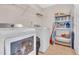 Functional laundry room equipped with modern appliances, storage shelves, and durable tiled flooring at 1309 Caribou Xing, Durham, NC 27713