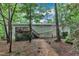 Back exterior view of home with a wooden deck accessible by stairs, surrounded by mature trees at 1311 Theodore Ln, Durham, NC 27703