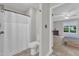 Clean bathroom with a toilet and shower, connecting to a bedroom with large window at 1311 Theodore Ln, Durham, NC 27703