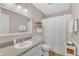 Well-lit bathroom featuring a single sink vanity, a neutral color palette, and a shower with a curtain at 1311 Theodore Ln, Durham, NC 27703