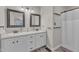 Bathroom featuring dual sinks, white cabinets, framed mirrors, and a shower with curtain at 1311 Theodore Ln, Durham, NC 27703