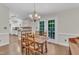 Cozy dining area adjacent to kitchen with French doors, classic chandelier and hardwood flooring at 1311 Theodore Ln, Durham, NC 27703