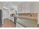 Well-lit kitchen featuring white cabinets, tile backsplash, modern appliances, and ample counter space at 1311 Theodore Ln, Durham, NC 27703