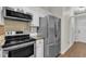 Close-up of kitchen stainless steel appliances and white cabinets with tan backsplash at 1311 Theodore Ln, Durham, NC 27703