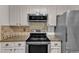 Kitchen featuring stainless steel oven, microwave and refrigerator with white cabinetry at 1311 Theodore Ln, Durham, NC 27703