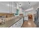 Bright kitchen showcasing counters, backsplash, stainless sink and view to dining area at 1311 Theodore Ln, Durham, NC 27703