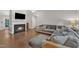 Spacious living room with hardwood floors, plush sectional sofa, fireplace, and a mounted television at 1311 Theodore Ln, Durham, NC 27703