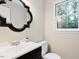 Elegant half bathroom featuring modern vanity, chic mirror, and serene natural lighting at 14 Gloucester Ct, Durham, NC 27713