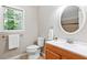 Bathroom featuring light tile flooring, wood vanity, and window at 14 Gloucester Ct, Durham, NC 27713