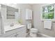 Bright bathroom with modern fixtures, white vanity, decorative mirror, and a window offering natural light at 14 Gloucester Ct, Durham, NC 27713