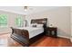 Spacious bedroom featuring a wooden bed frame, matching nightstand, and bright natural lighting at 14 Gloucester Ct, Durham, NC 27713