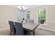 Inviting dining room features a modern chandelier and views of the wooded landscape at 14 Gloucester Ct, Durham, NC 27713