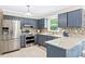 Modern kitchen with stainless steel appliances, blue cabinets, and bright tile flooring at 14 Gloucester Ct, Durham, NC 27713