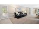 Inviting living room featuring stylish black leather couch, natural light, and seamless transition to the kitchen at 14 Gloucester Ct, Durham, NC 27713