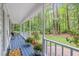 Spacious wrap around porch with blue painted flooring and white railing and a view of the wooded backyard at 14 Gloucester Ct, Durham, NC 27713