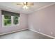 Bedroom with neutral color palette, ceiling fan, and large window allowing natural light at 1420 Seabrook Ave, Cary, NC 27511