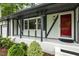 Inviting covered entrance with red door to a Tudor-style home with a landscaped front yard at 1420 Seabrook Ave, Cary, NC 27511