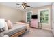 Bedroom featuring a ceiling fan, soft pink accents, a comfortable bed, and bright natural light coming through the windows at 1603 Timber Wolf Dr, Durham, NC 27713