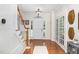 Bright foyer with hardwood floors, a staircase with white railing, and a view of the front door at 1603 Timber Wolf Dr, Durham, NC 27713