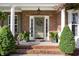 Inviting front entrance featuring a brick facade, decorated door with wreath, and well-maintained landscaping at 1603 Timber Wolf Dr, Durham, NC 27713