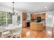 Sunlit kitchen with wood cabinets, stainless steel appliances, breakfast nook with white table, and hardwood floors at 1603 Timber Wolf Dr, Durham, NC 27713