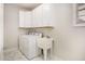 The laundry room has a washer and dryer with plenty of cabinet space and marble floors at 1603 Timber Wolf Dr, Durham, NC 27713