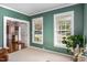 Inviting office space with neutral carpeting, green walls, natural light, and elegant decor at 1603 Timber Wolf Dr, Durham, NC 27713