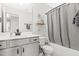 Well-lit bathroom featuring a combination tub and shower with vanity and cabinet, offering practical storage at 18 Dot Dr, Wendell, NC 27591
