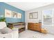 Cozy Bedroom with a wooden crib, dresser with changing station, and comfortable armchair in soft colors at 18 Dot Dr, Wendell, NC 27591