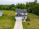 Aerial view of home with manicured lawn, long driveway, and fenced backyard, in a quiet neighborhood at 18 Dot Dr, Wendell, NC 27591