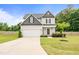 Charming two-story home featuring a manicured lawn, attached garage, and welcoming front entrance at 18 Dot Dr, Wendell, NC 27591