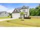 Beautiful two-story home showcasing a well-maintained yard, an attached garage and mature tree at 18 Dot Dr, Wendell, NC 27591