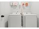 Functional laundry room with white washer and dryer, with storage shelf above for laundry products at 18 Dot Dr, Wendell, NC 27591